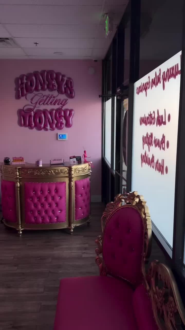Tufted pink and gold reception desk under the Honeys Getting Money wall sign