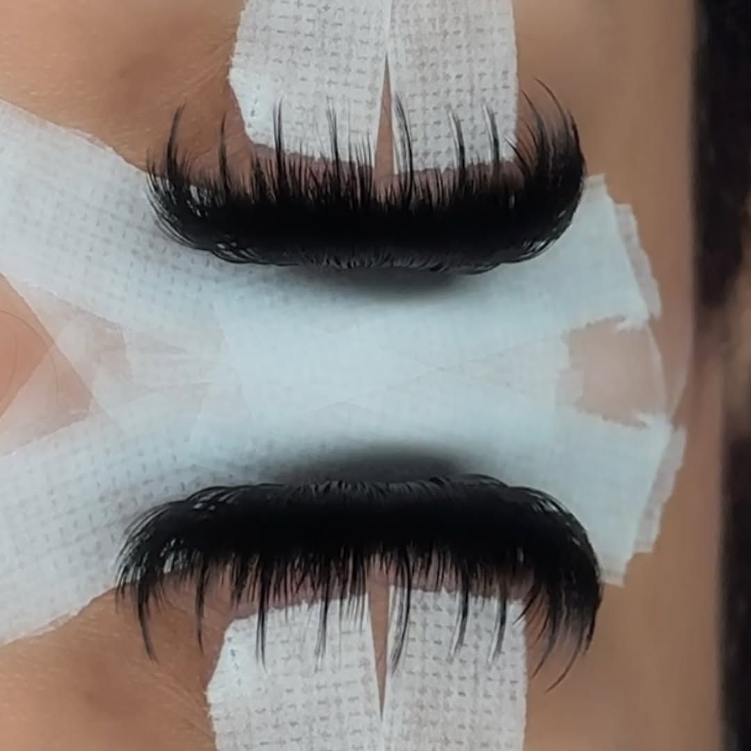 Wispy set close-up during application, eyes taped